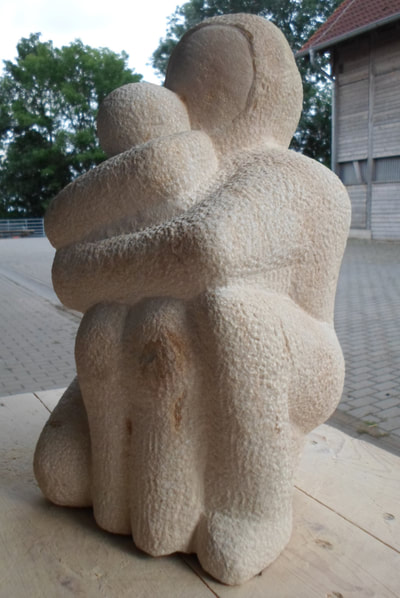 Während des Bildhauerkurses entstandene Steinskulptur zeigt eine Umarmung